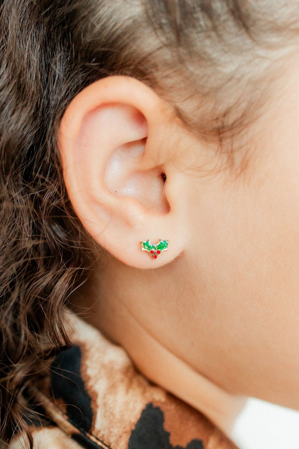 LINNY CO Holly Berry screwback stud earrings for kids & little girls — hypoallergenic, waterproof stainless steel with secure screwback backs, shown on model.