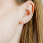 LINNY CO Horseshoe Silver screwback stud earrings for kids & little girls — hypoallergenic, waterproof stainless steel with secure screwback backs, shown on model.