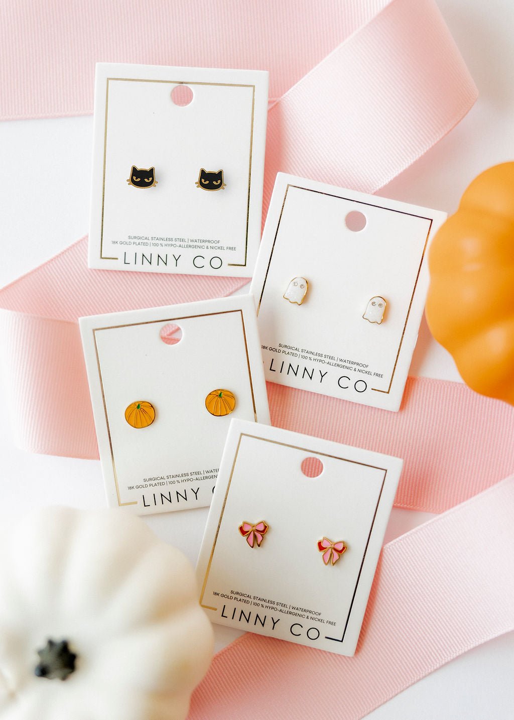 LINNY CO Knox Pumpkin screwback stud earrings for kids & little girls — hypoallergenic, waterproof stainless steel with secure screwback backs, flat-lay styling.