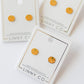 LINNY CO Knox Pumpkin screwback stud earrings for kids & little girls — hypoallergenic, waterproof stainless steel with secure screwback backs, flat-lay styling.