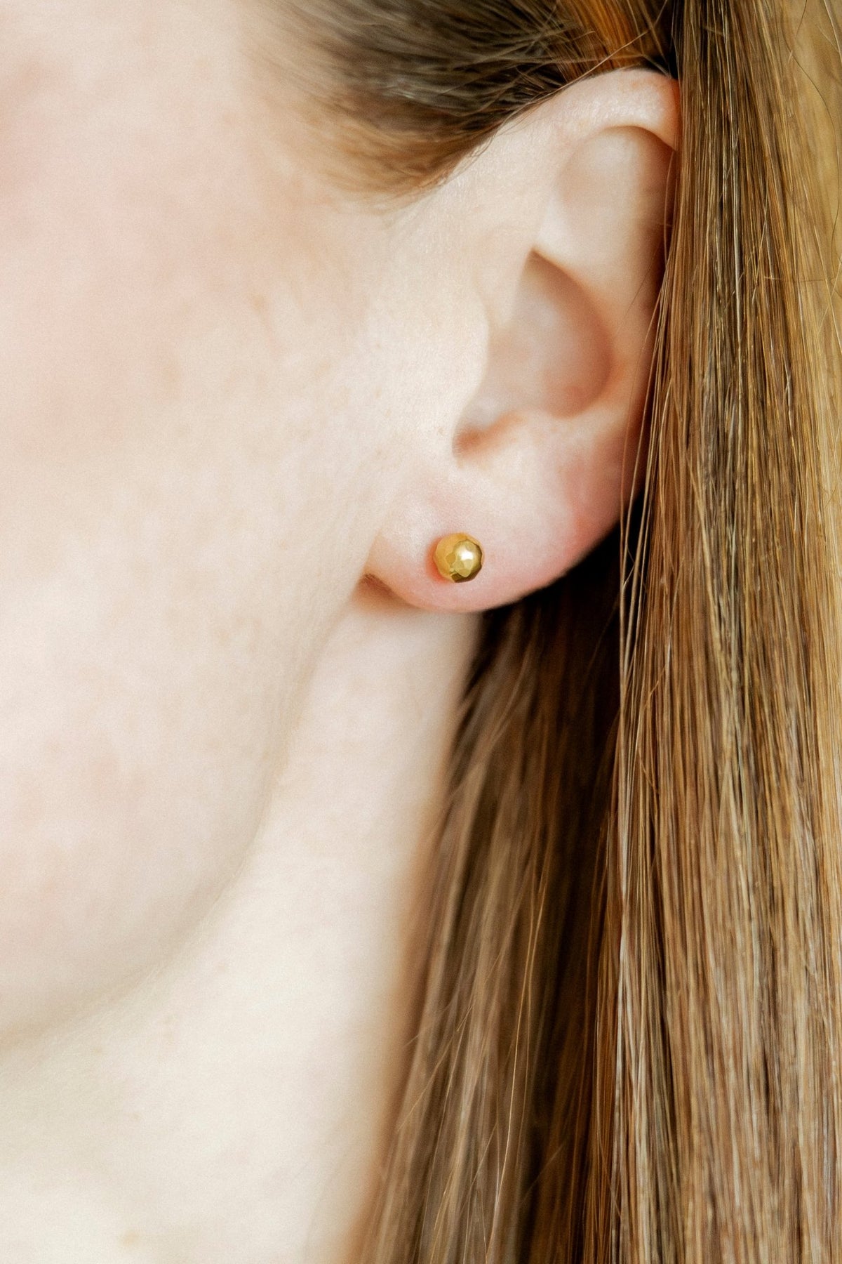 LINNY CO Lydia Gold screwback stud earrings for kids & little girls — hypoallergenic, waterproof stainless steel with secure screwback backs, shown on model.