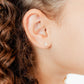 LINNY CO Lyla Flower Clear screwback stud earrings for kids & little girls — hypoallergenic, waterproof stainless steel with secure screwback backs, shown on model.