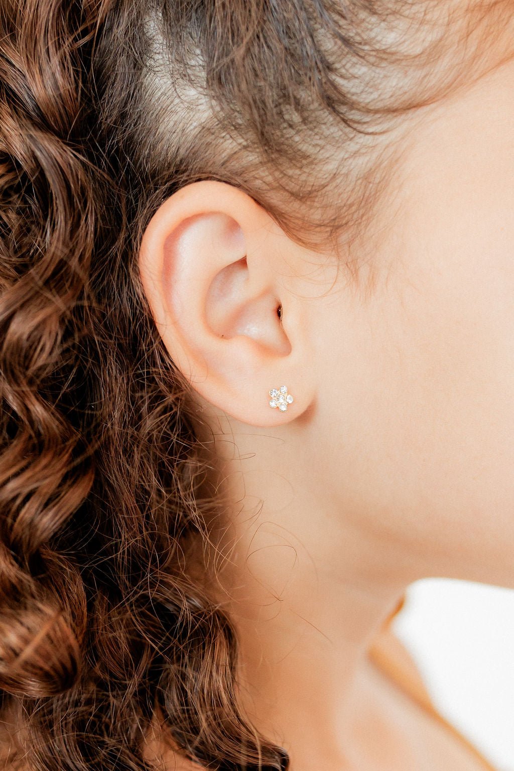 LINNY CO Lyla Flower Clear screwback stud earrings for kids & little girls — hypoallergenic, waterproof stainless steel with secure screwback backs, shown on model.