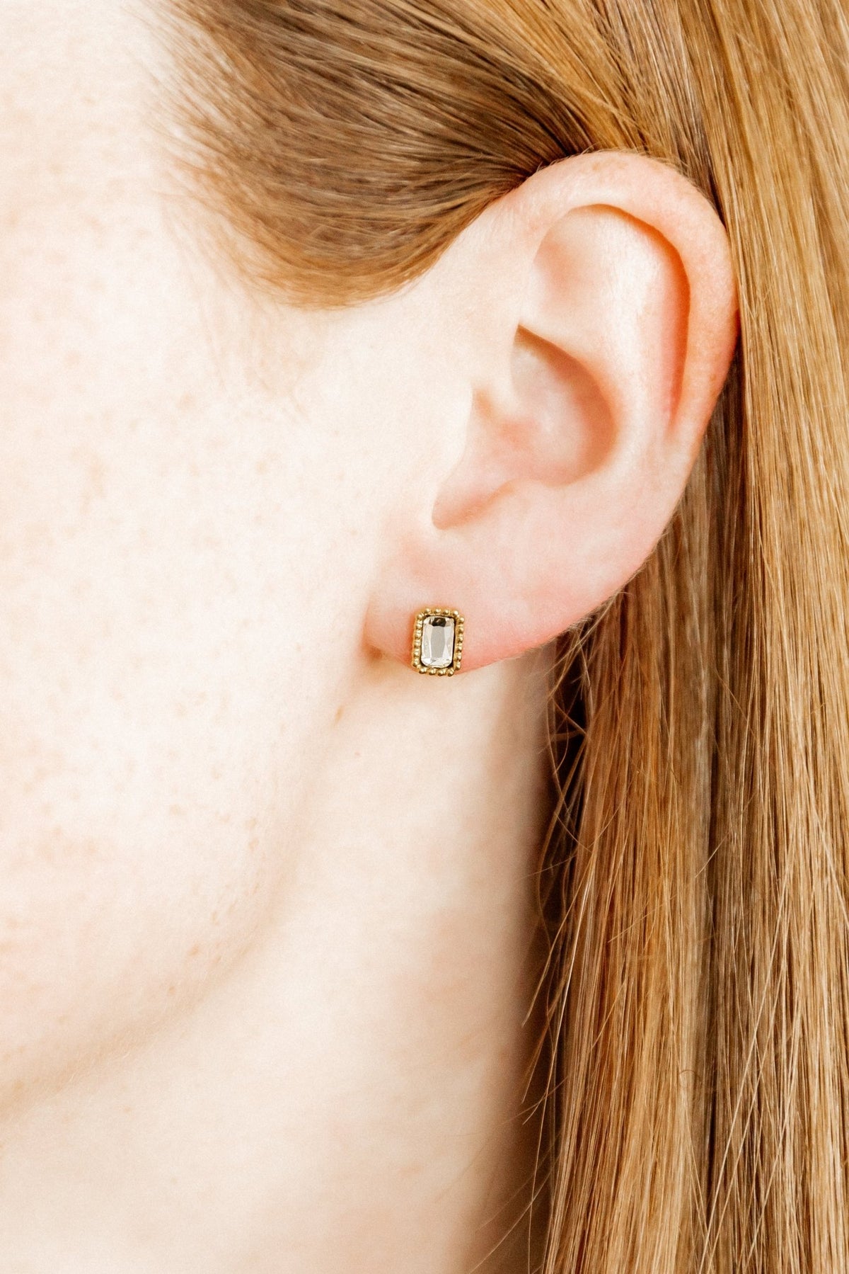 LINNY CO Madison Gold Clear screwback stud earrings for kids & little girls — hypoallergenic, waterproof stainless steel with secure screwback backs, shown on model.
