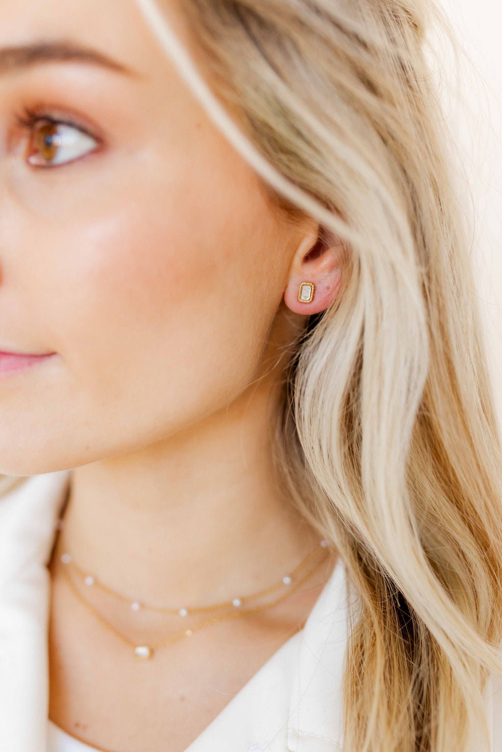 LINNY CO Madison Gold Clear screwback stud earrings for kids & little girls — hypoallergenic, waterproof stainless steel with secure screwback backs, shown on model.