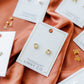 LINNY CO Madison Gold Clear screwback stud earrings for kids & little girls — hypoallergenic, waterproof stainless steel with secure screwback backs, shown on model.