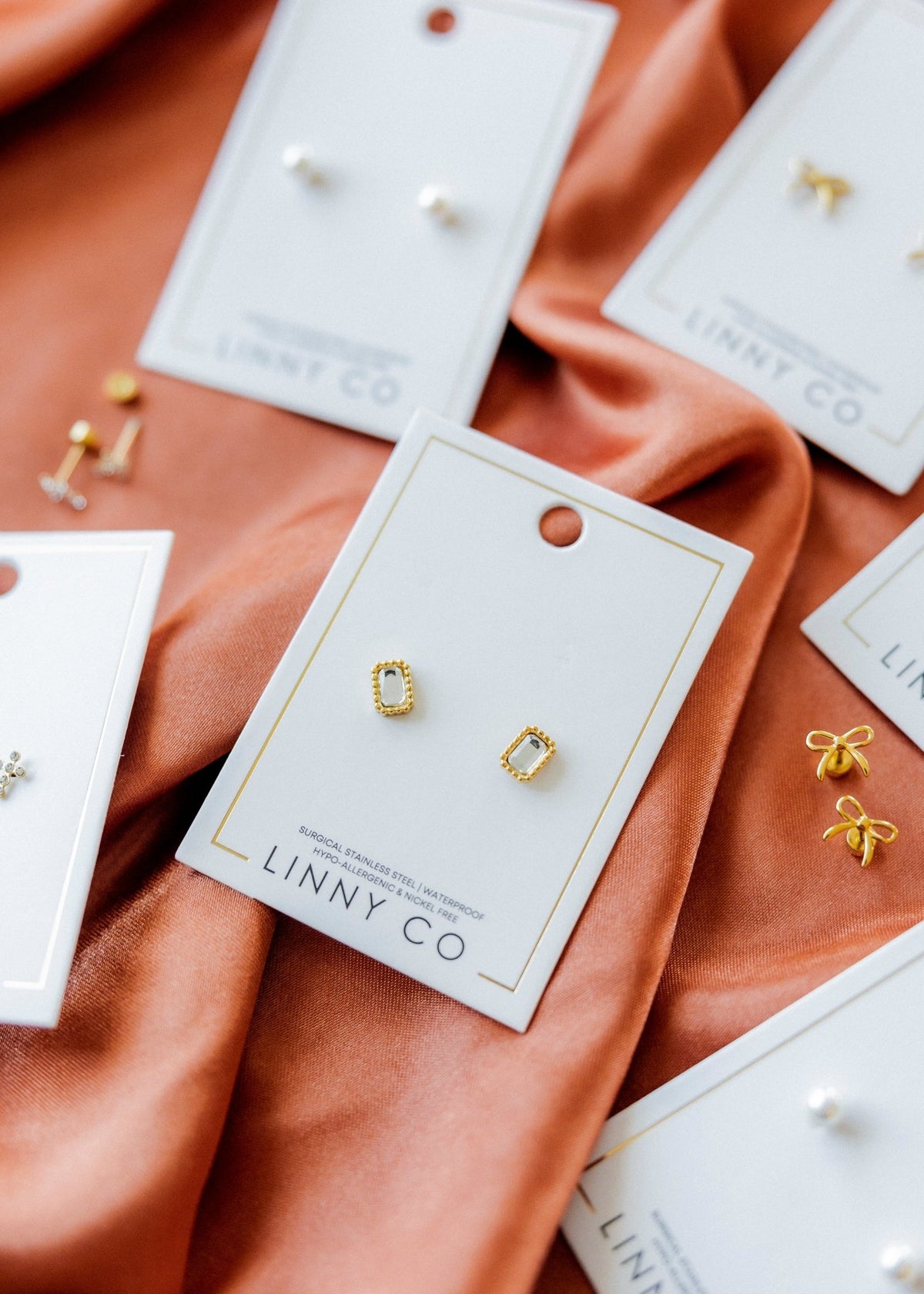 LINNY CO Madison Gold Clear screwback stud earrings for kids & little girls — hypoallergenic, waterproof stainless steel with secure screwback backs, shown on model.