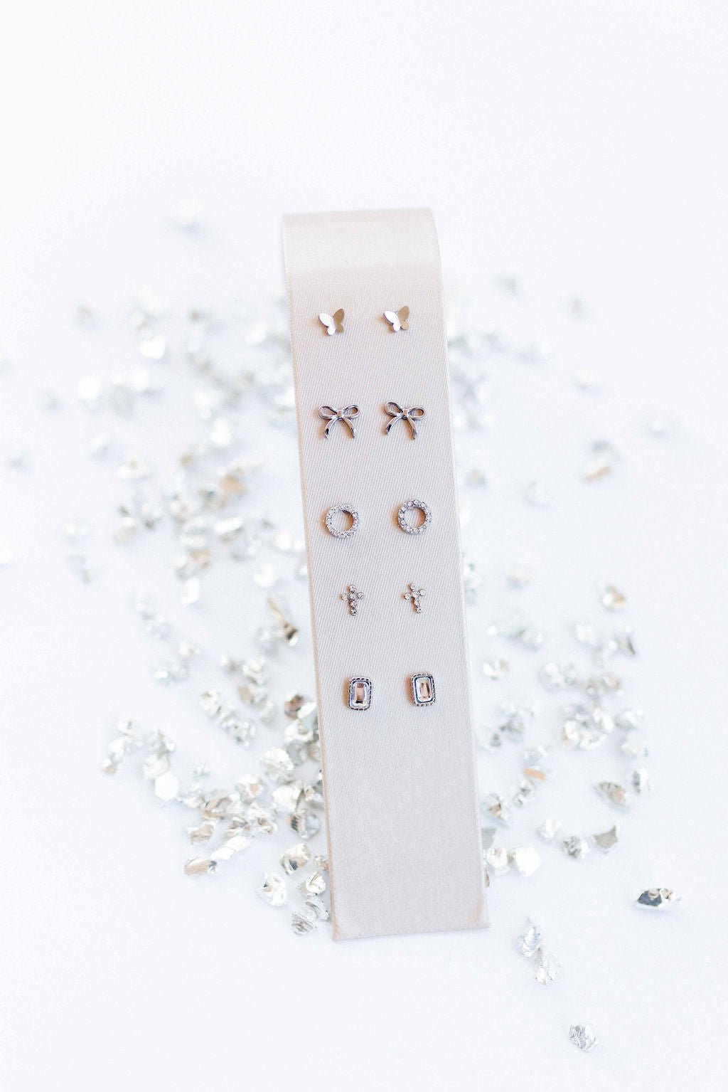 LINNY CO Madison Silver Clear screwback stud earrings for kids & little girls — hypoallergenic, waterproof stainless steel with secure screwback backs, flat-lay styling.
