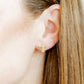 LINNY CO Menorah screwback stud earrings for kids & little girls — hypoallergenic, waterproof stainless steel with secure screwback backs, shown on model.