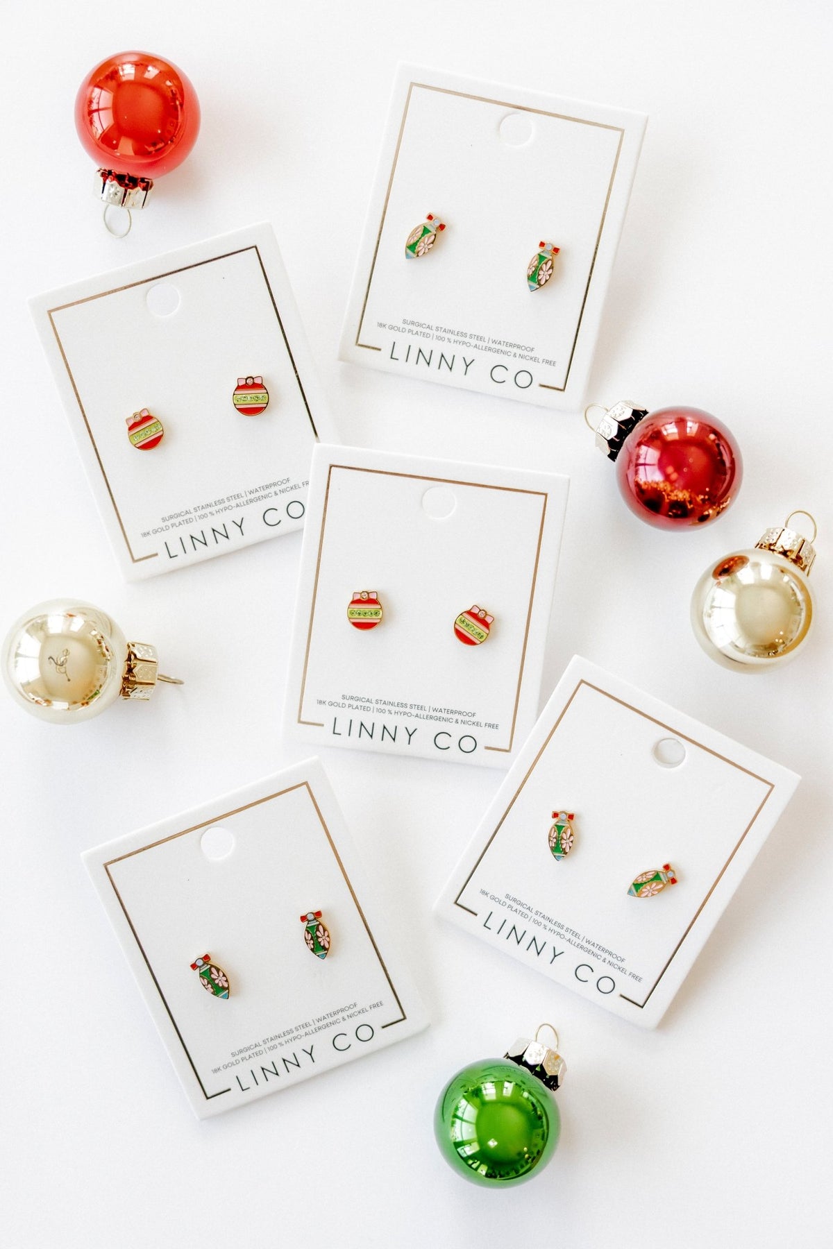 LINNY CO Merritt Ornament screwback stud earrings for kids & little girls — hypoallergenic, waterproof stainless steel with secure screwback backs, flat-lay styling.