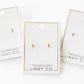 LINNY CO Micro Tally Gold screwback stud earrings for kids & little girls — hypoallergenic, waterproof stainless steel with secure screwback backs, flat-lay styling.