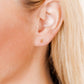 LINNY CO Micro Tally Gold screwback stud earrings for kids & little girls — hypoallergenic, waterproof stainless steel with secure screwback backs, shown on model.