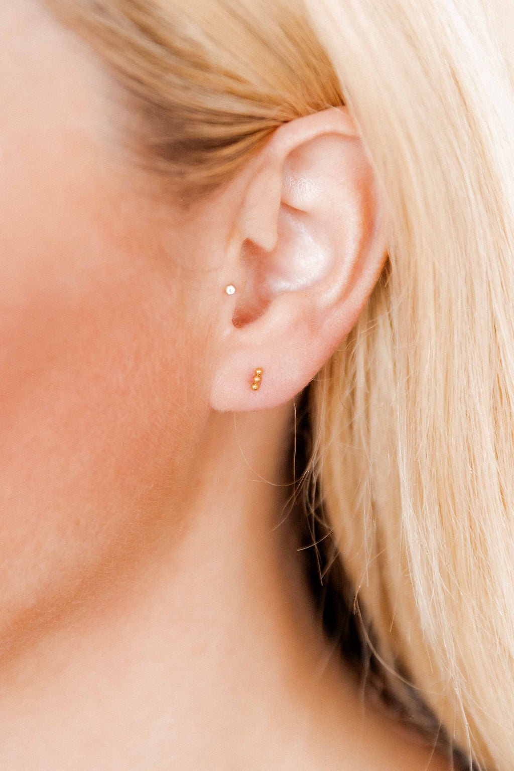 LINNY CO Micro Tally Gold screwback stud earrings for kids & little girls — hypoallergenic, waterproof stainless steel with secure screwback backs, shown on model.