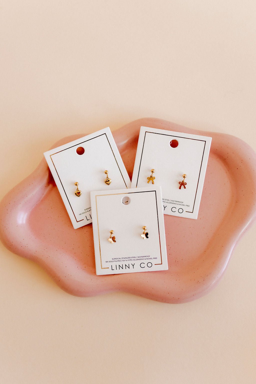 LINNY CO Millie Butterfly screwback stud earrings for kids & little girls — hypoallergenic, waterproof stainless steel with secure screwback backs, flat-lay styling.