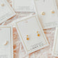 LINNY CO Millie Heart Gold screwback stud earrings for kids & little girls — hypoallergenic, waterproof stainless steel with secure screwback backs, flat-lay styling.