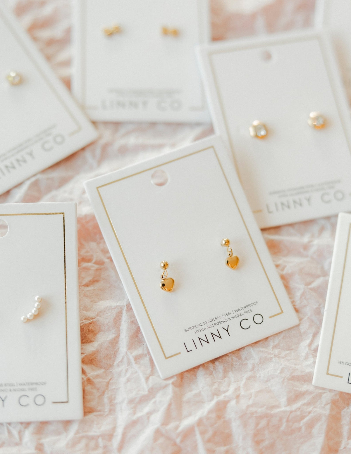 LINNY CO Millie Heart Gold screwback stud earrings for kids & little girls — hypoallergenic, waterproof stainless steel with secure screwback backs, flat-lay styling.