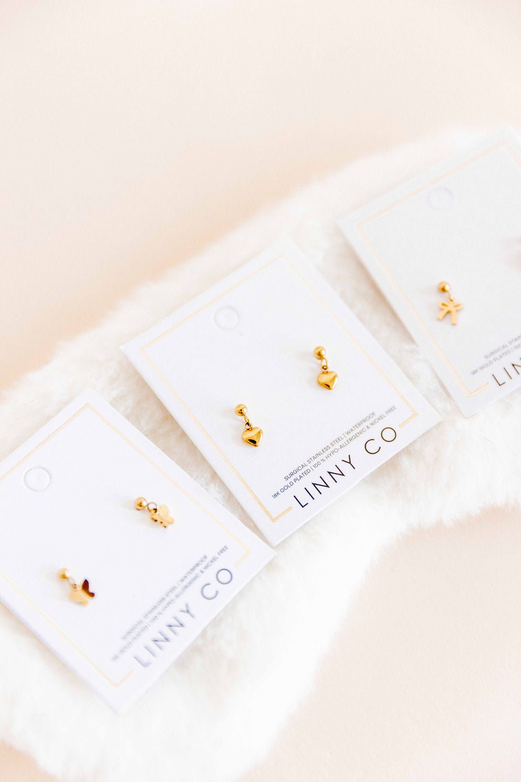 LINNY CO Millie Heart Gold screwback stud earrings for kids & little girls — hypoallergenic, waterproof stainless steel with secure screwback backs, flat-lay styling.