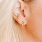 LINNY CO Millie Heart Gold screwback stud earrings for kids & little girls — hypoallergenic, waterproof stainless steel with secure screwback backs, shown on model.