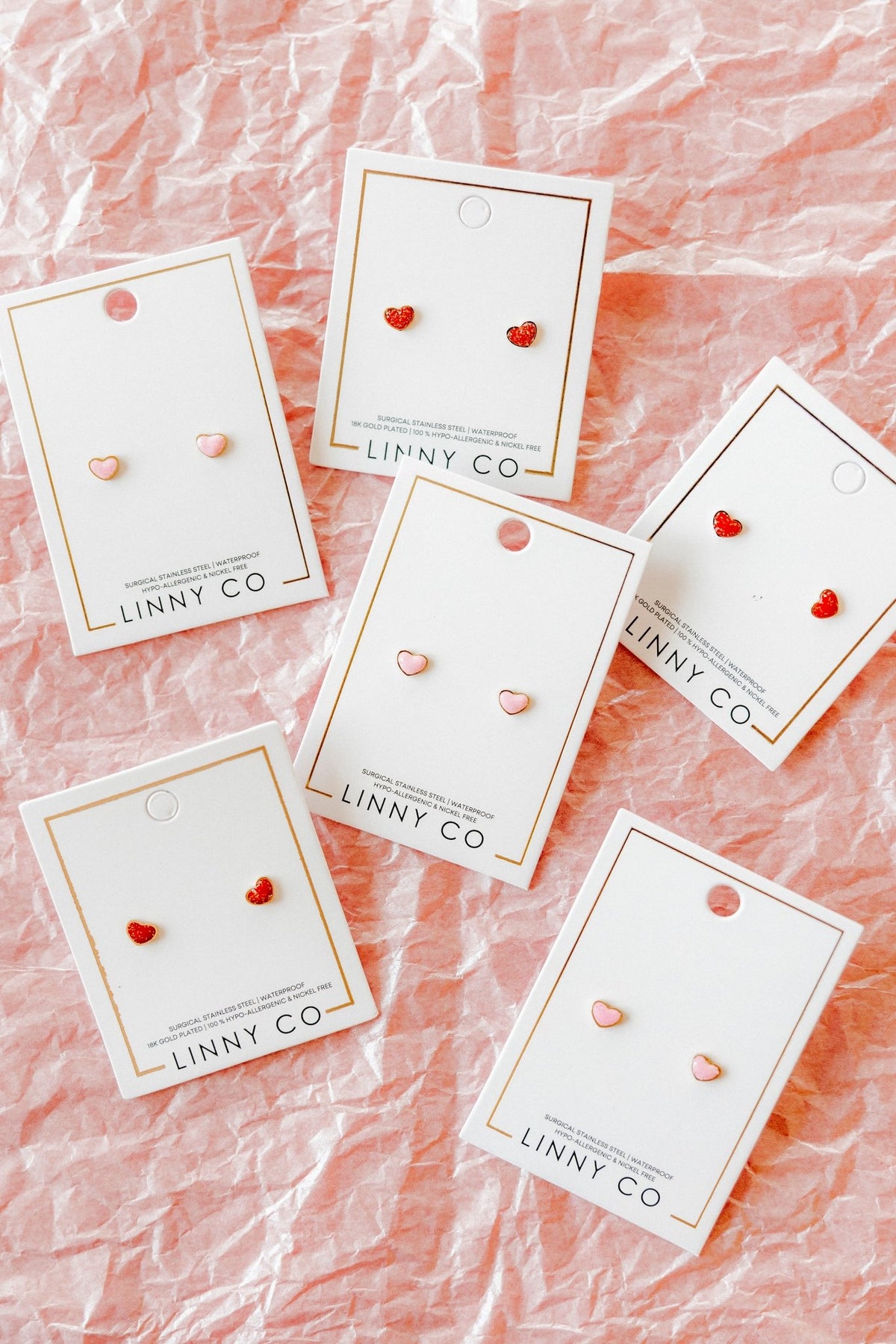 LINNY CO Nora Heart Red screwback stud earrings for kids & little girls — hypoallergenic, waterproof stainless steel with secure screwback backs, shown on model.