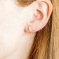 LINNY CO Nova Gold screwback stud earrings for kids & little girls — hypoallergenic, waterproof stainless steel with secure screwback backs, shown on model.