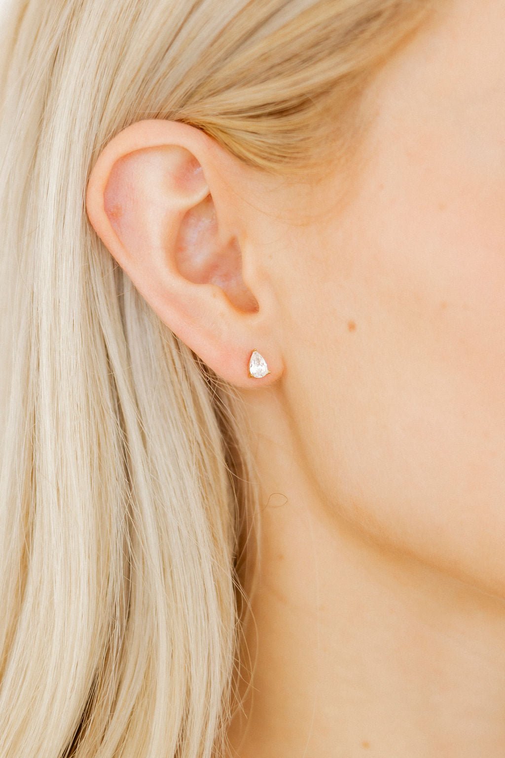 LINNY CO Paige Pear Gold screwback stud earrings for kids & little girls — hypoallergenic, waterproof stainless steel with secure screwback backs, shown on model.