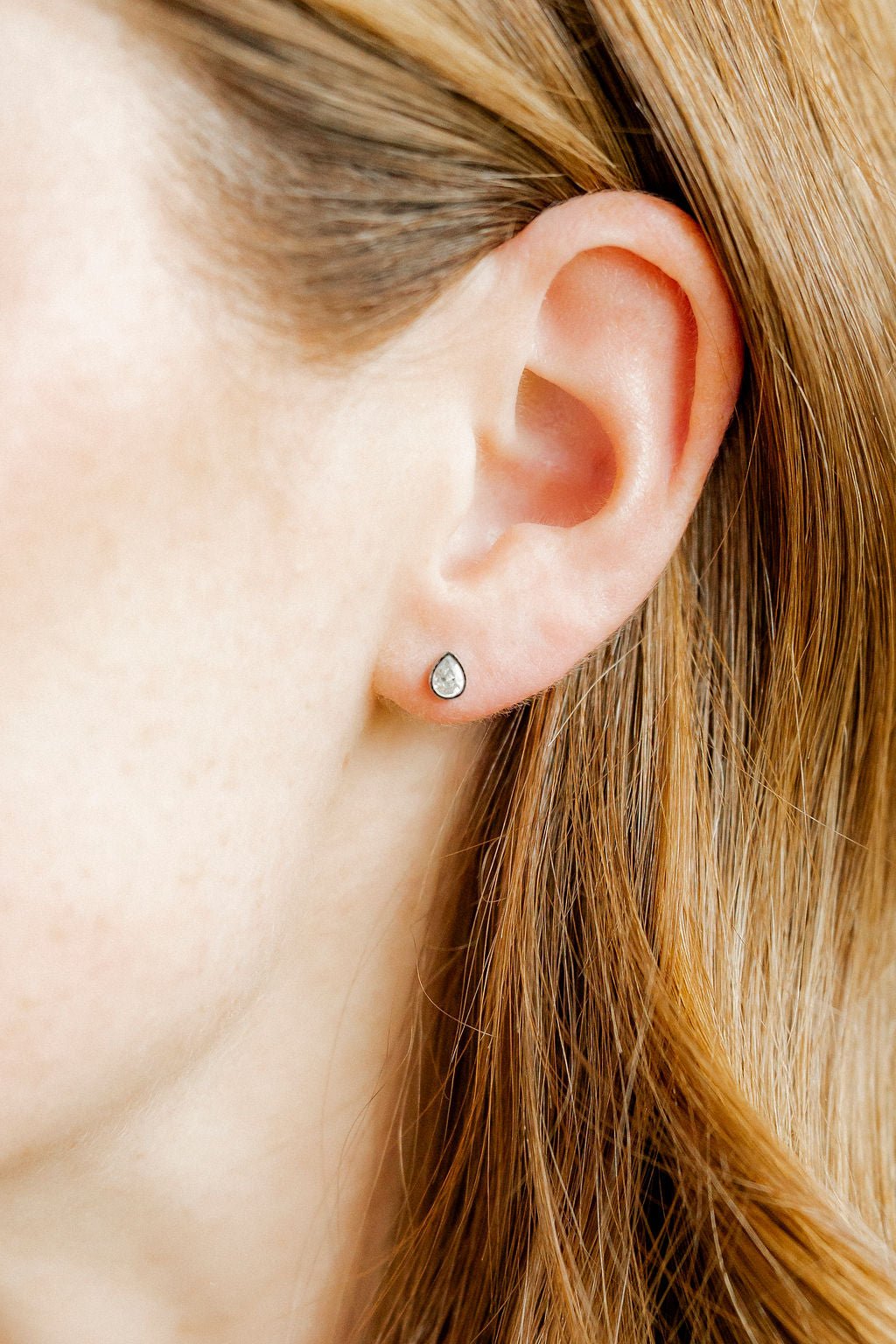 LINNY CO Paloma Pear Silver screwback stud earrings for kids & little girls — hypoallergenic, waterproof stainless steel with secure screwback backs, shown on model.