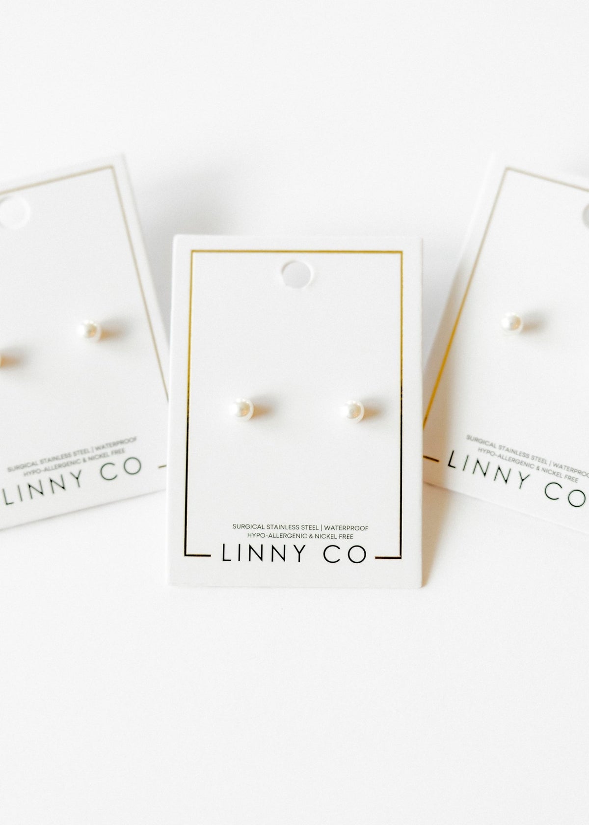 LINNY CO Payton Pearl White 5mm screwback stud earrings for kids & little girls — hypoallergenic, waterproof stainless steel with secure screwback backs, flat-lay styling.