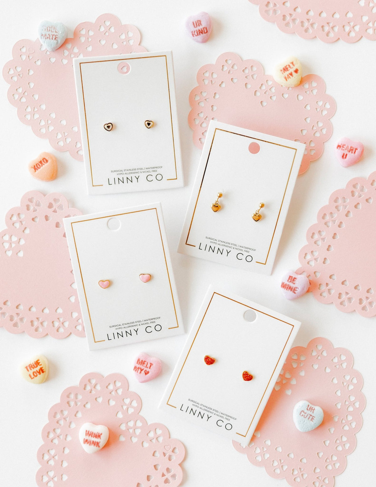 LINNY CO Polly Heart screwback stud earrings for kids & little girls — hypoallergenic, waterproof stainless steel with secure screwback backs, flat-lay styling.