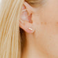 LINNY CO Poppy screwback stud earrings for kids & little girls — hypoallergenic, waterproof stainless steel with secure screwback backs, shown on model.