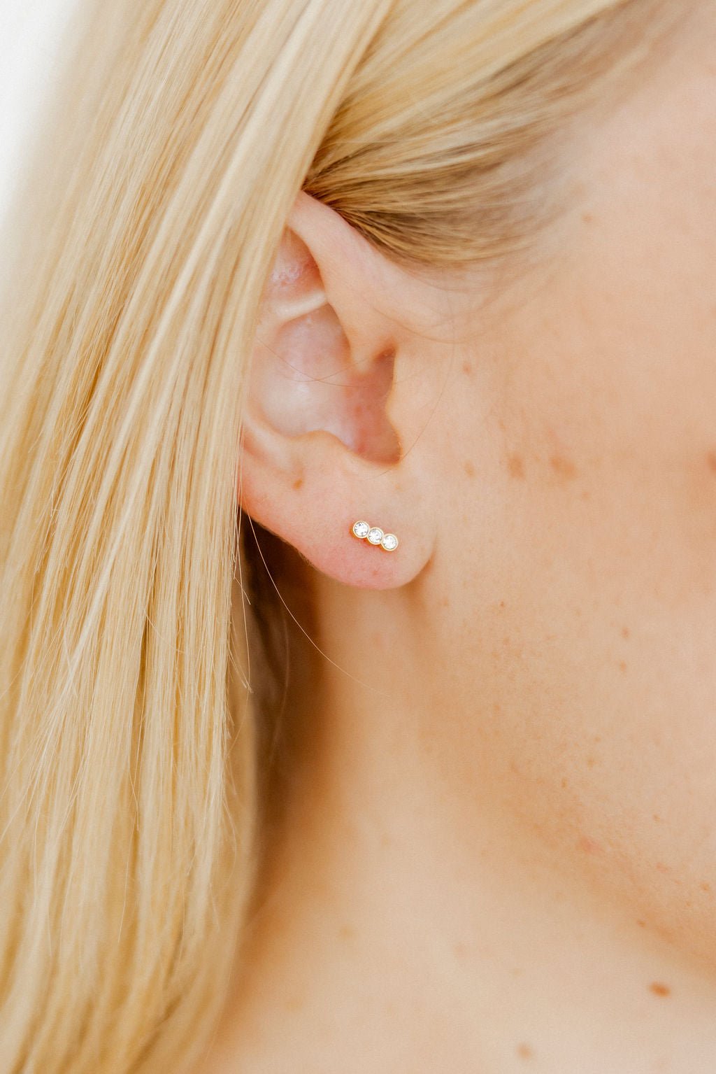 LINNY CO Poppy screwback stud earrings for kids & little girls — hypoallergenic, waterproof stainless steel with secure screwback backs, shown on model.
