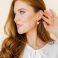 LINNY CO Sadie Bow Gold screwback stud earrings for kids & little girls — hypoallergenic, waterproof stainless steel with secure screwback backs, shown on model.