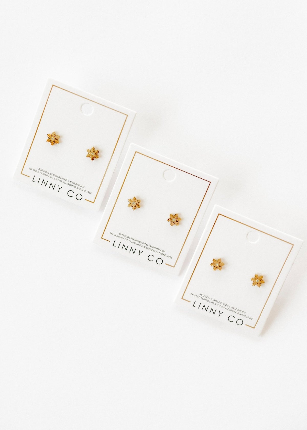 LINNY CO Snowflake Gold screwback stud earrings for kids & little girls — hypoallergenic, waterproof stainless steel with secure screwback backs, flat-lay styling.