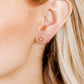 LINNY CO Snowflake Gold screwback stud earrings for kids & little girls — hypoallergenic, waterproof stainless steel with secure screwback backs, shown on model.