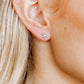 LINNY CO Snowflake Silver screwback stud earrings for kids & little girls — hypoallergenic, waterproof stainless steel with secure screwback backs, shown on model.