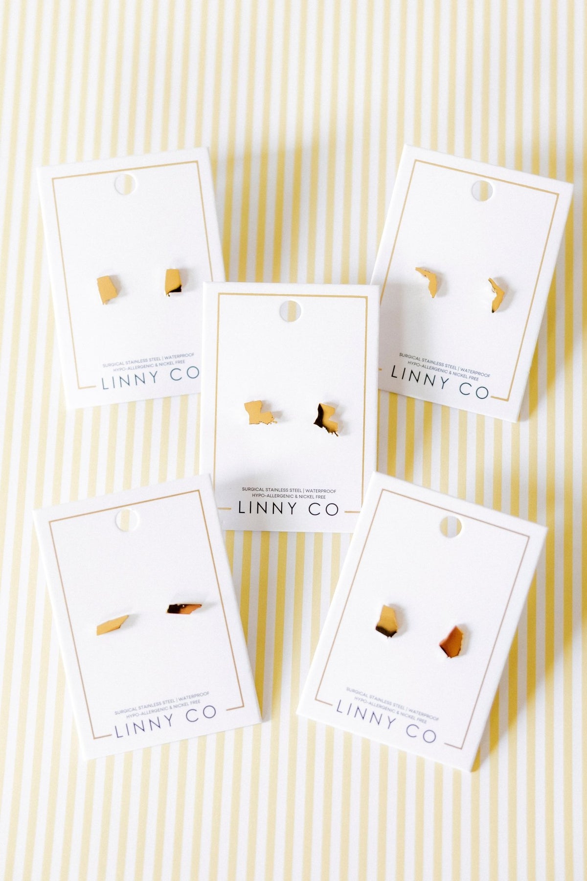 LINNY CO State of Louisiana screwback stud earrings for kids & little girls — hypoallergenic, waterproof stainless steel with secure screwback backs, flat-lay styling.