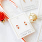 LINNY CO Taffy screwback stud earrings for kids & little girls — hypoallergenic, waterproof stainless steel with secure screwback backs, flat-lay styling.