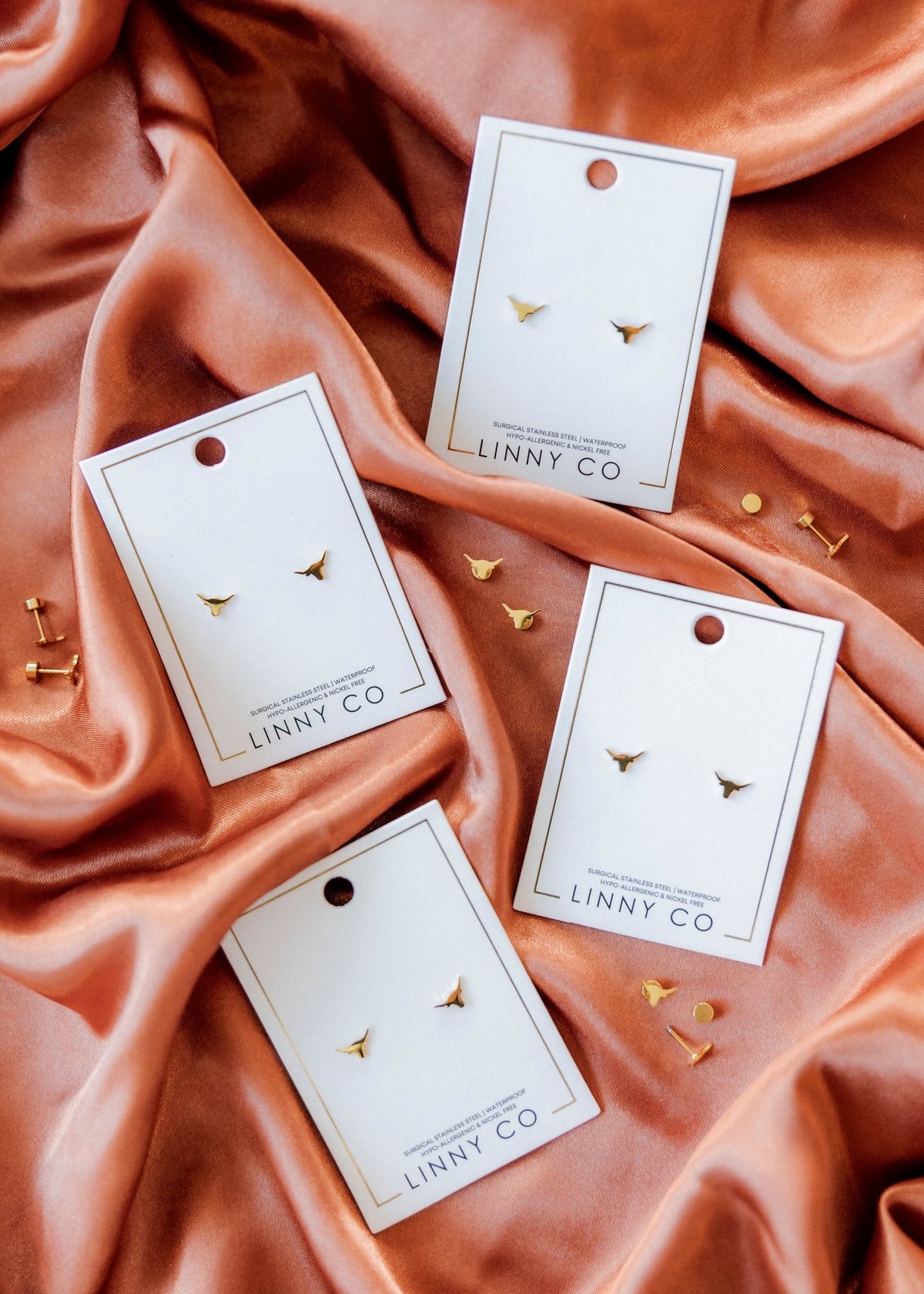 LINNY CO Texas Steer Gold screwback stud earrings for kids & little girls — hypoallergenic, waterproof stainless steel with secure screwback backs, shown on model.